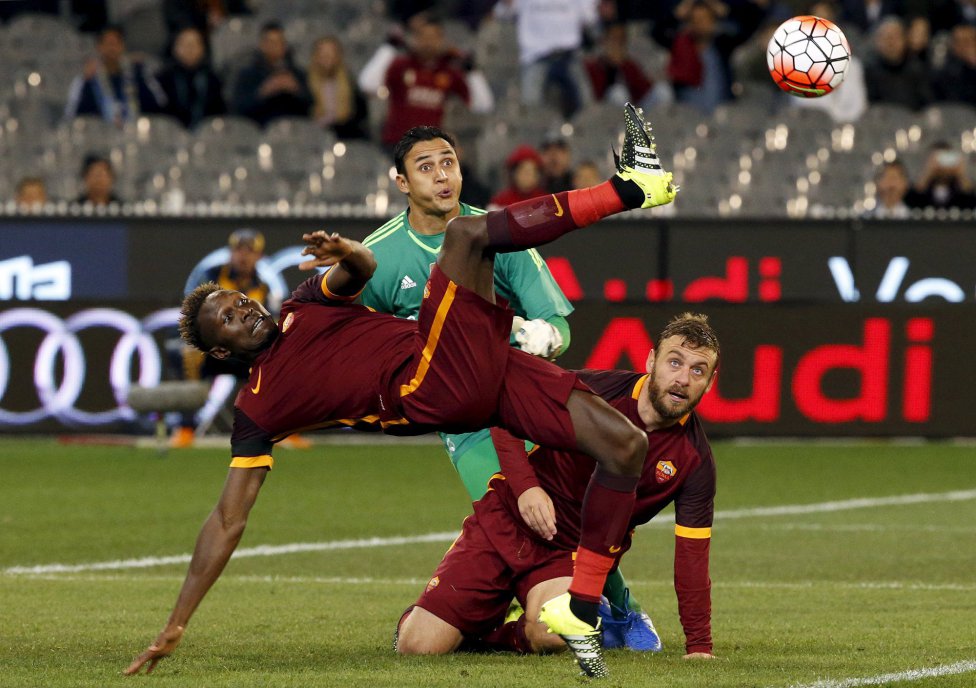 Real Madrid's goalkeeper Keilor Navas watches as AS Roma's Mapou Yanga Mbiwa jumps to kick the ball next to teammate Daniele De Rossi during their International Champions Cup soccer match at the Melbourne Cricket Ground, Australia