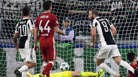 Juventus' forward from Argentina Gonzalo Higuain (R) scores during the UEFA Champion's League Group D football match Juventus vs Olympiacos on September 27, 2017 at the Juventus stadium in Turin.  / AFP PHOTO / Miguel MEDINA
